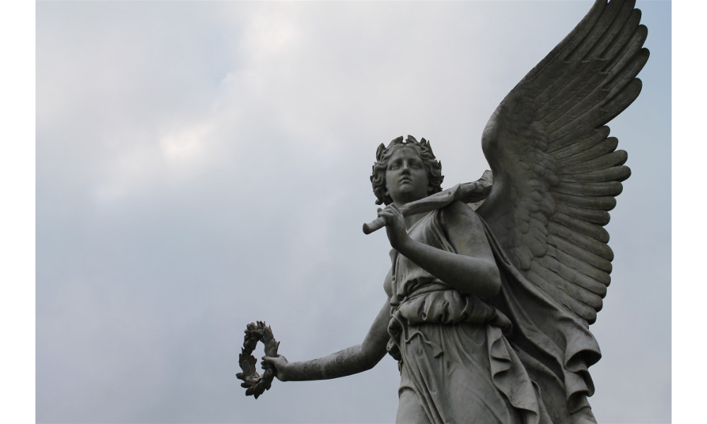 Escultura de um anjo com céu ao fundo