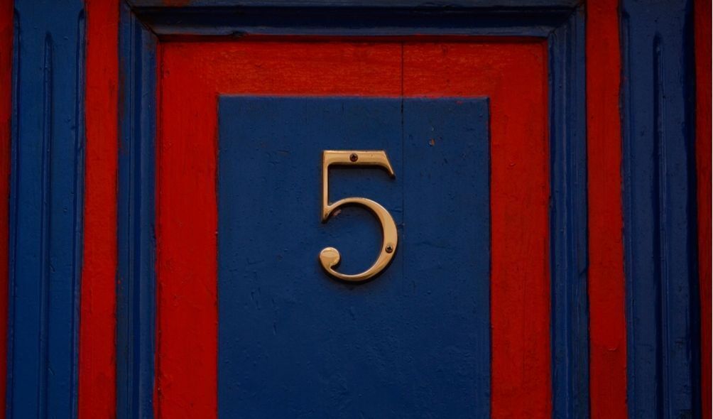 Número 5 em dourado pregado em uma porta