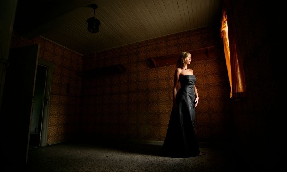 mulher com vestido preto num lugar escuro
