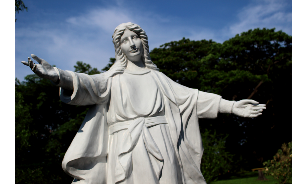 Imagem de uma escultura de Nossa Senhora de braços abertos.