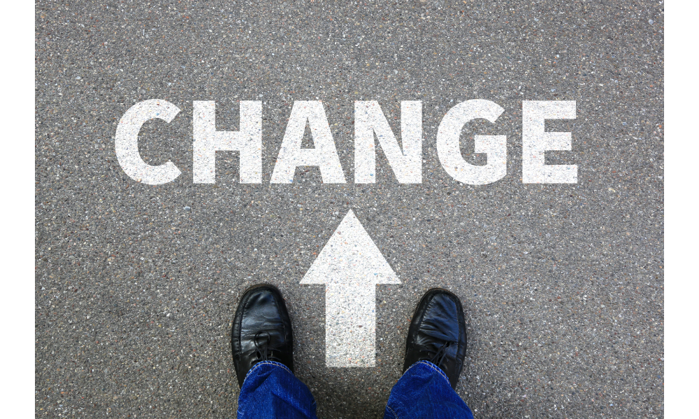 Pés apoiados no chão junto de da palavra "change" (mudança) e uma seta para a frente.