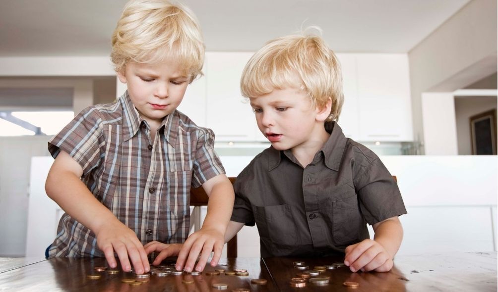 Meninos gêmeos contando moedas