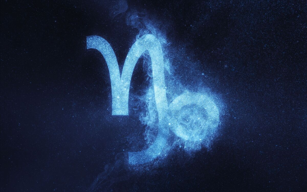 Símbolo do signo de Capricórnio azul em fundo escuro.