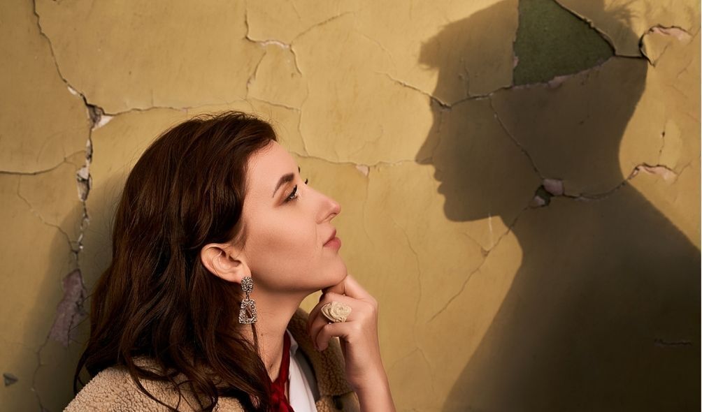 Mulher olhando apaixonada para a sombra de um homem projetada na parede