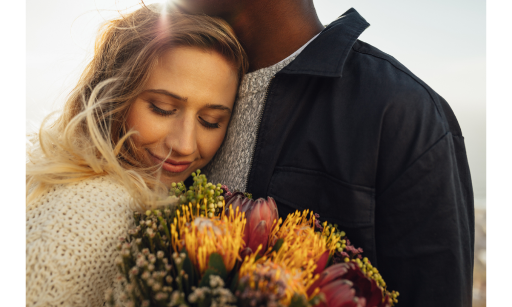 Casal de abraçando, mulher com buquê de flores.