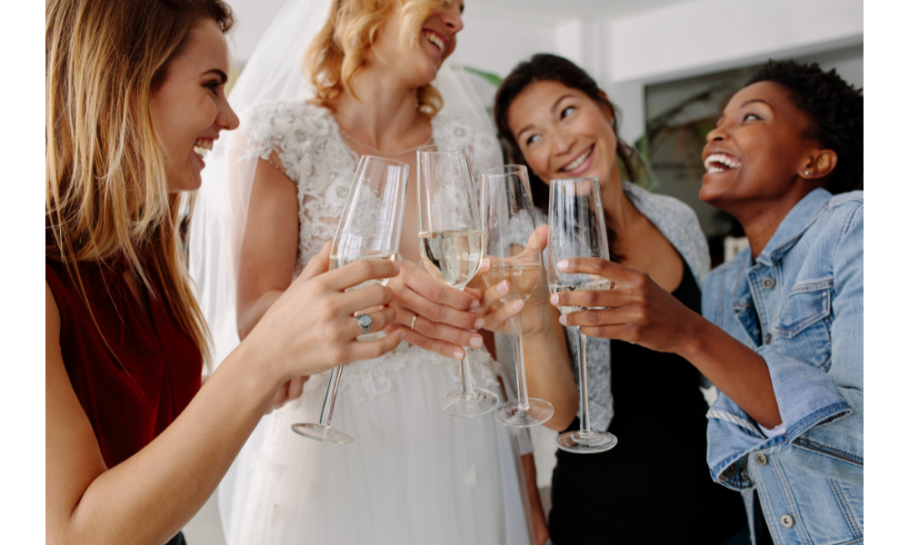 Noiva comemorando com as amigas bebendo champagne.