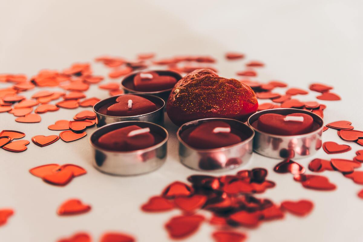 Velas vermelhas rodeadas por pétala de rosas