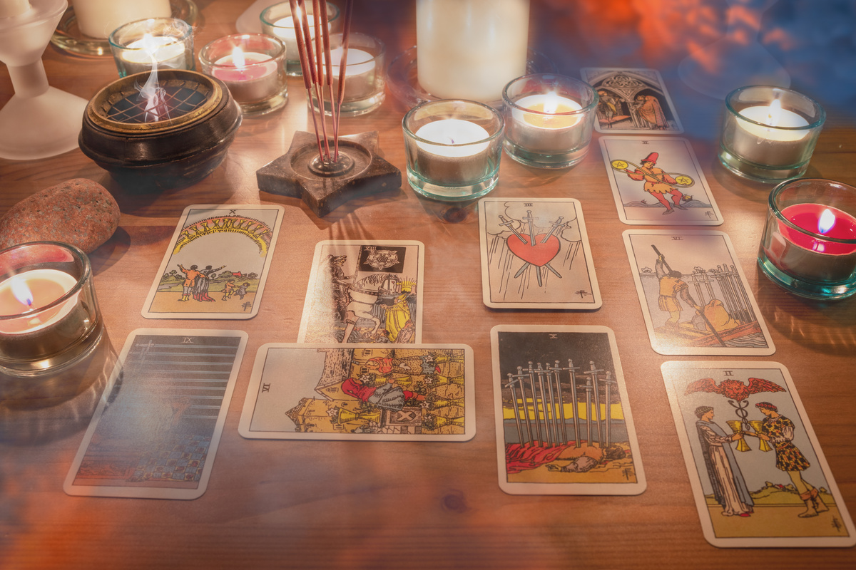 Uma mesa com várias cartas de tarot e velas
