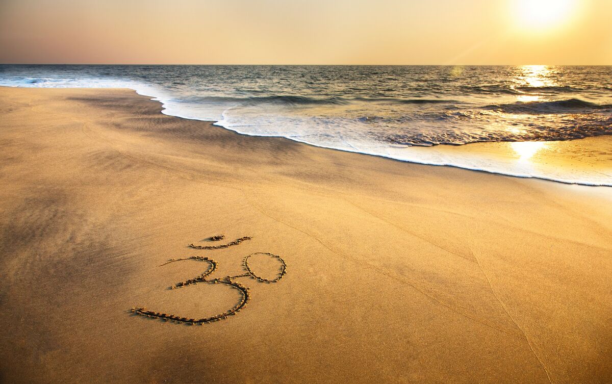 Símbolo do Om marcado em areia de praia.