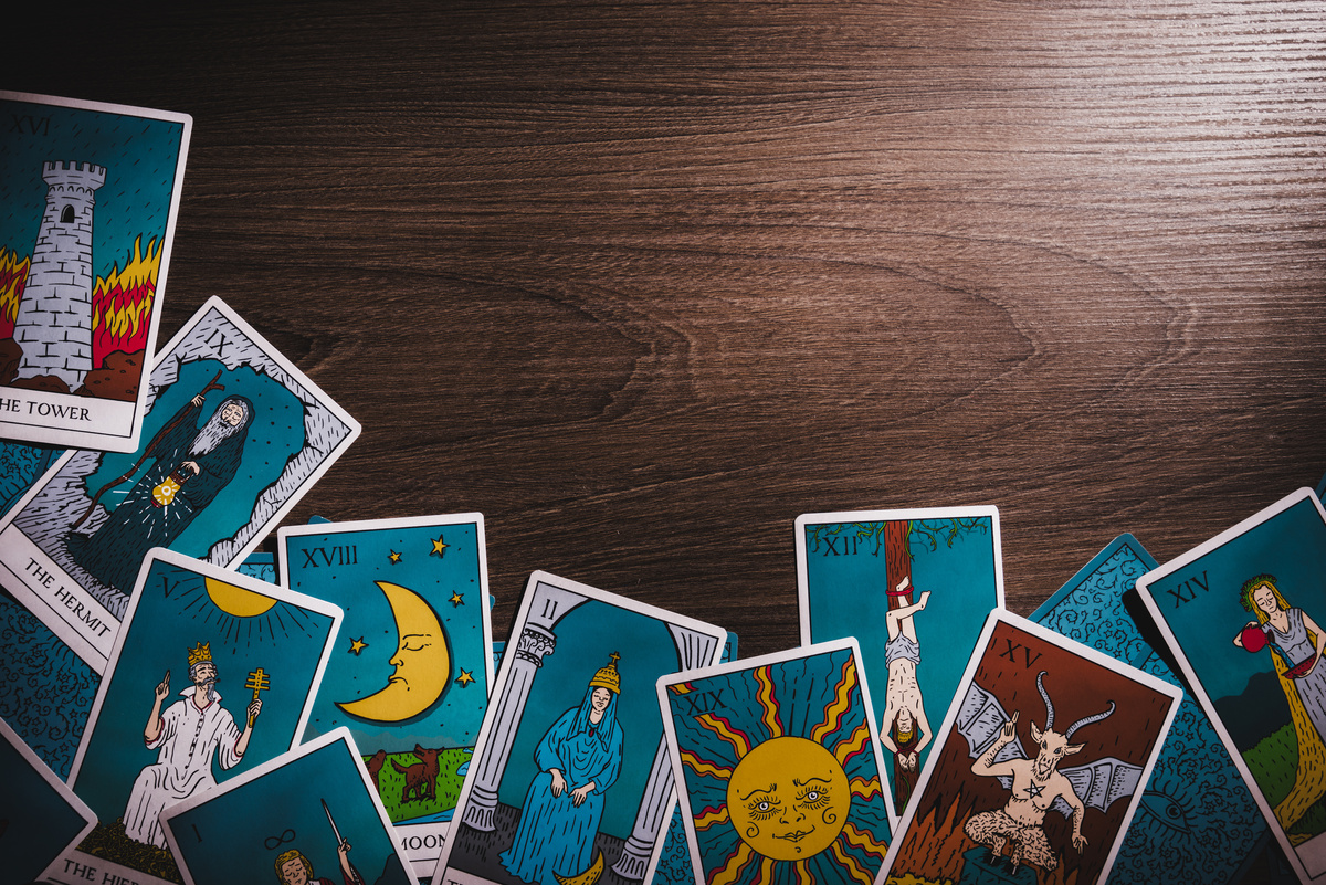 Imagem de cartas de tarot espalhadas sobre uma mesa de madeira