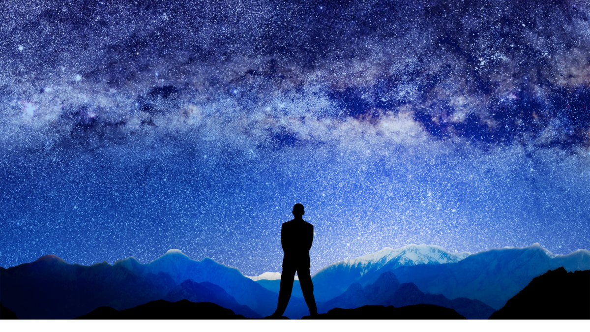 Homem diante de um céu estrelado.