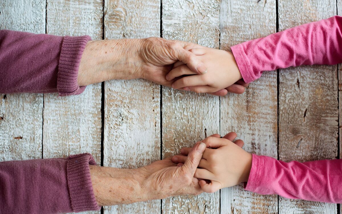 Avó e neta segurando as mãos.