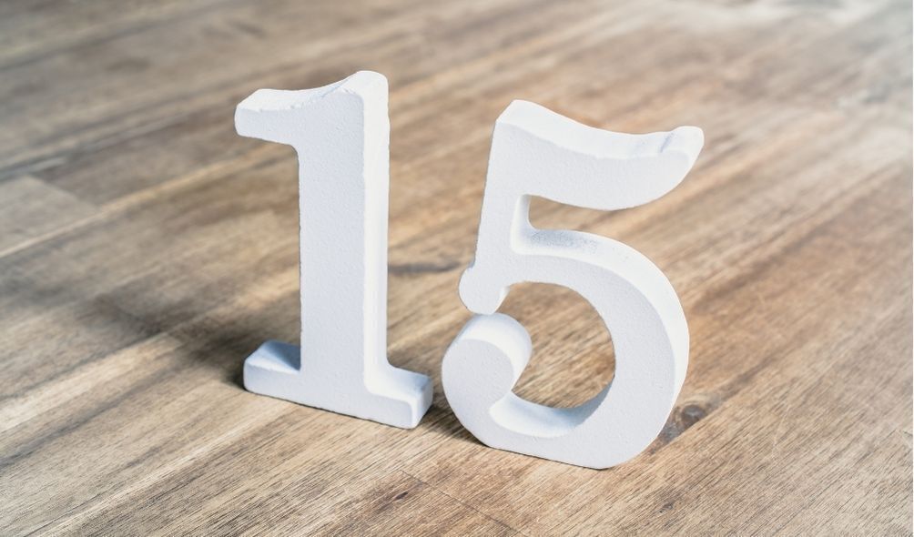 Número 15 em branco, em cima de mesa de madeira