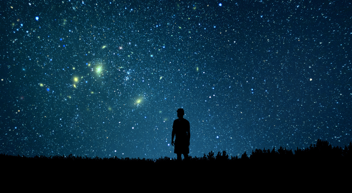 Sombra de pessoa observando os astros no céu.