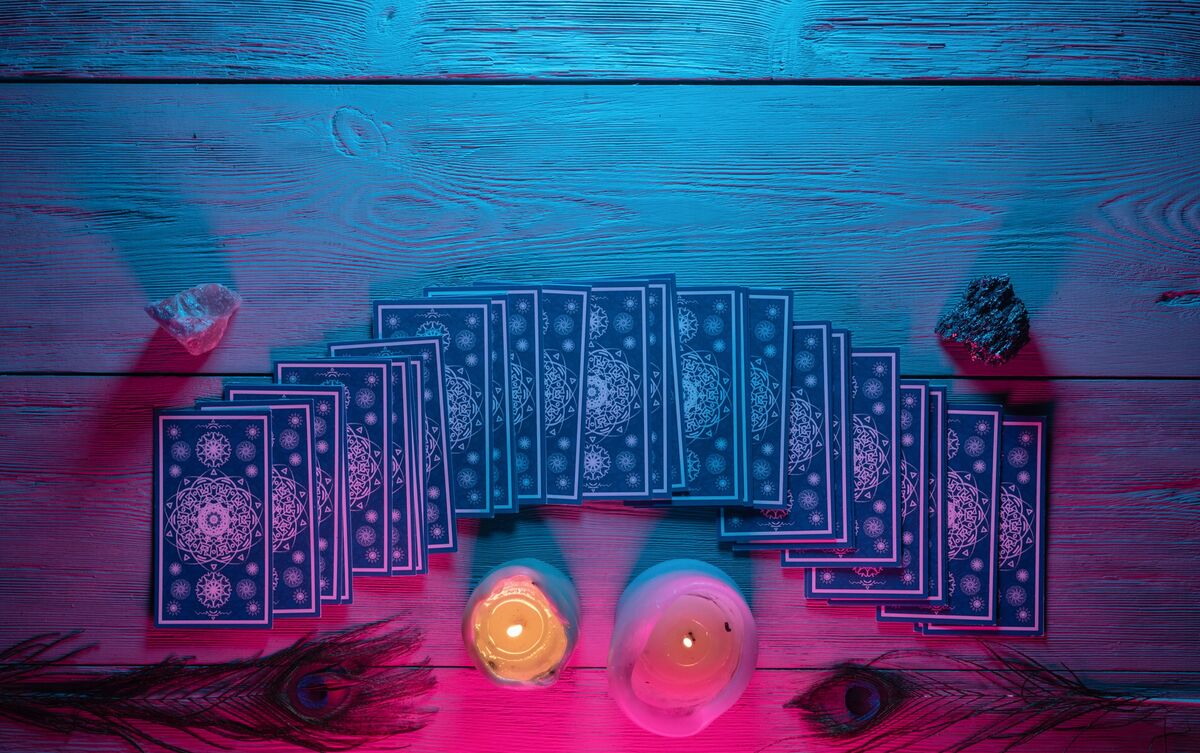 Cartas de Tarot enfileiradas sobre mesa.