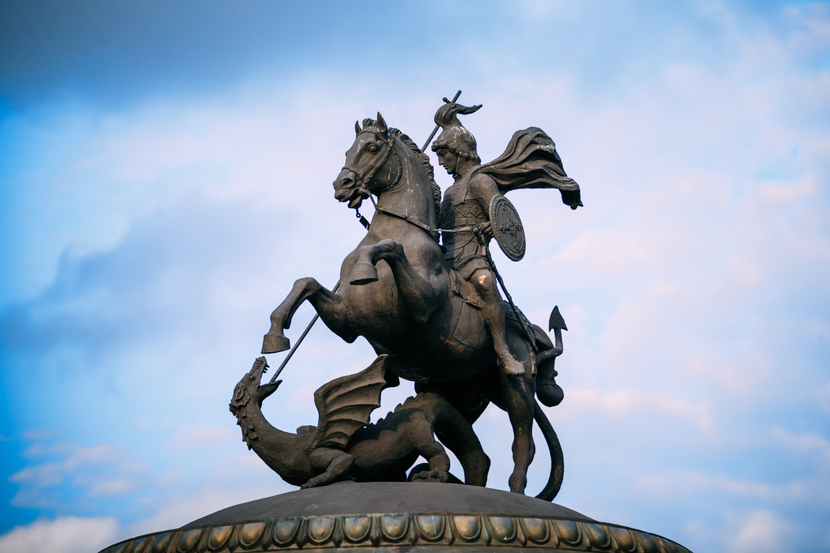 Estátua de São Jorge empunhando espada contra dragão.