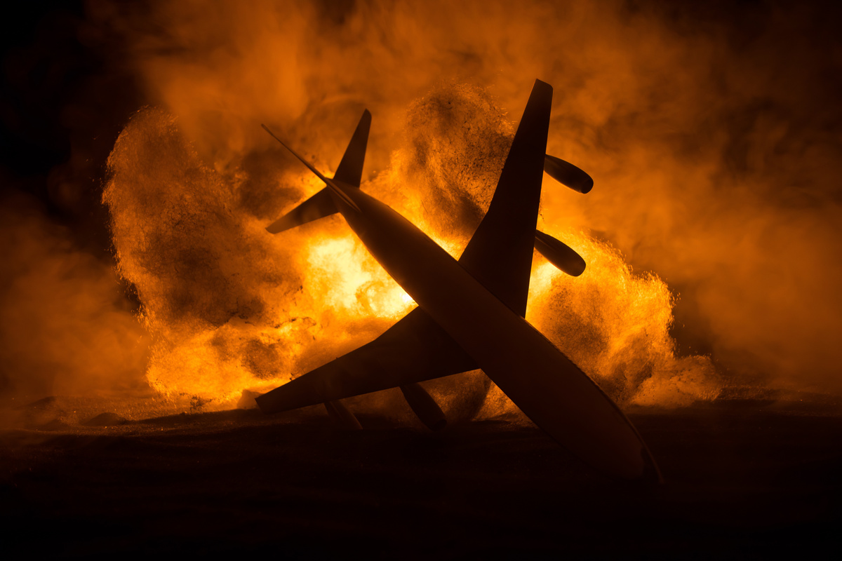 Sombra de avião em chamas durante a noite. 