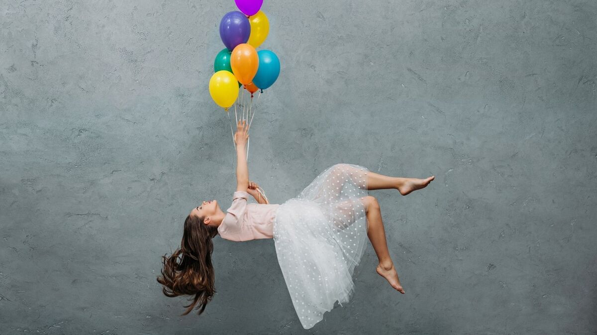 Mulher levitando com balões.