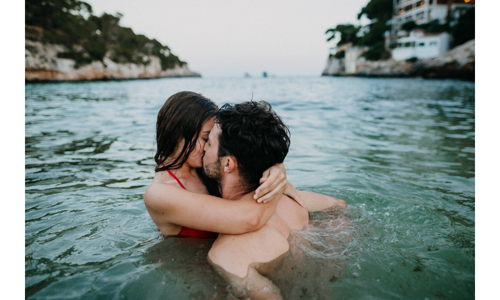 Casal de beijando no mar.