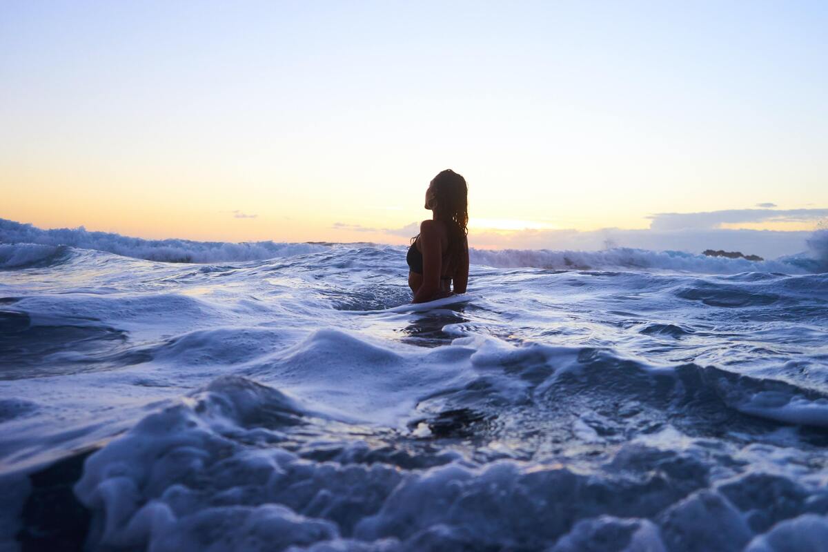 Mulher em pé no mar.