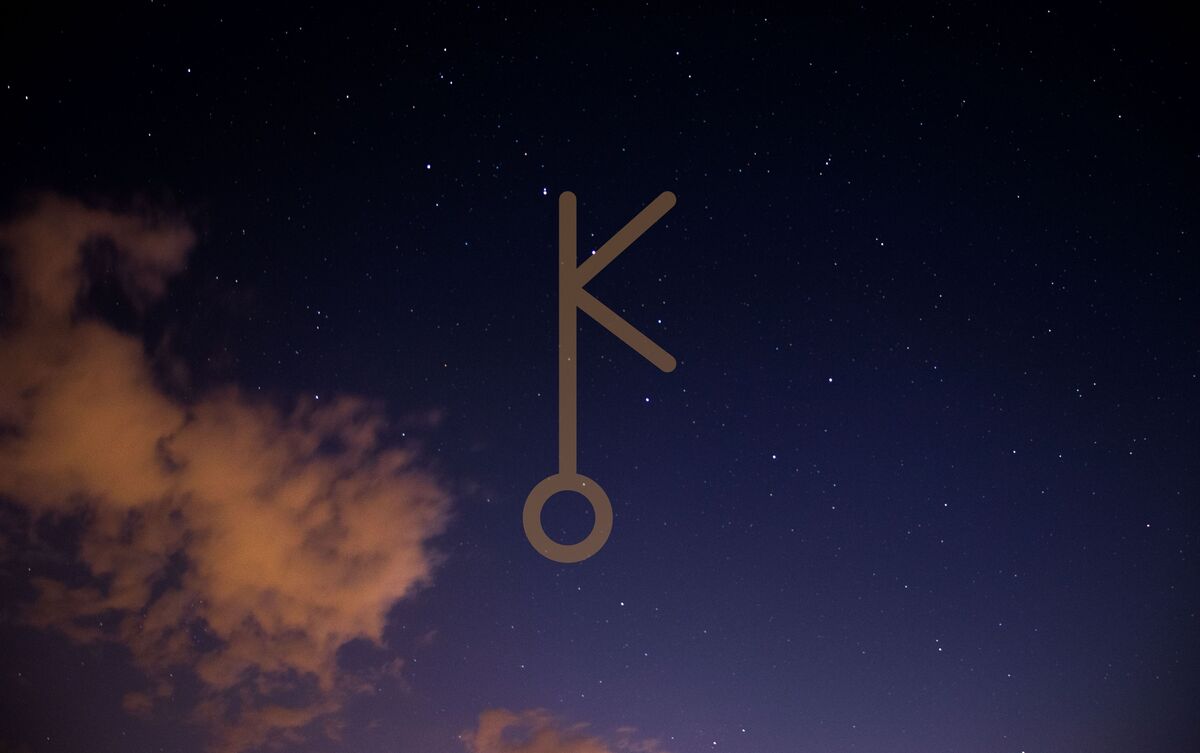 Símbolo de Quíron em céu estrelado.