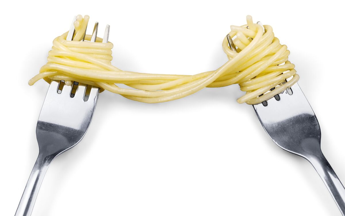 Dois garfos segurando macarrão espaguete.