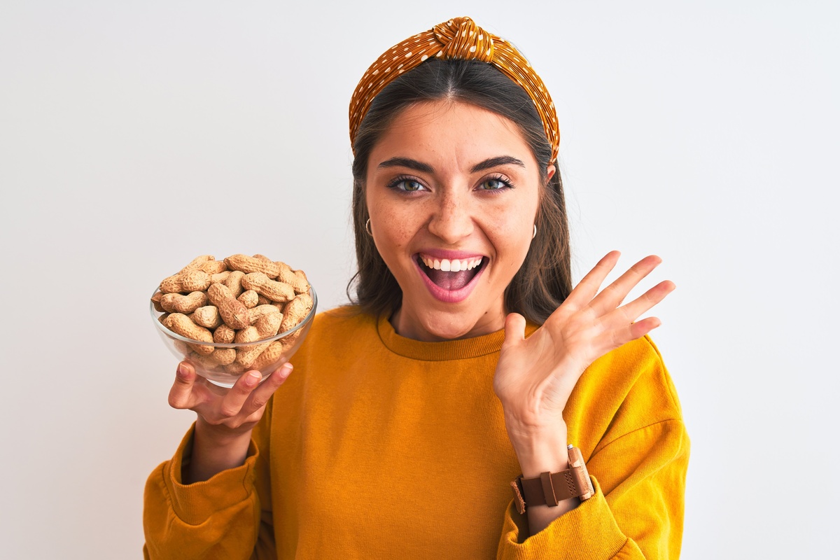 Um mulher com um pote de amendoins na mão