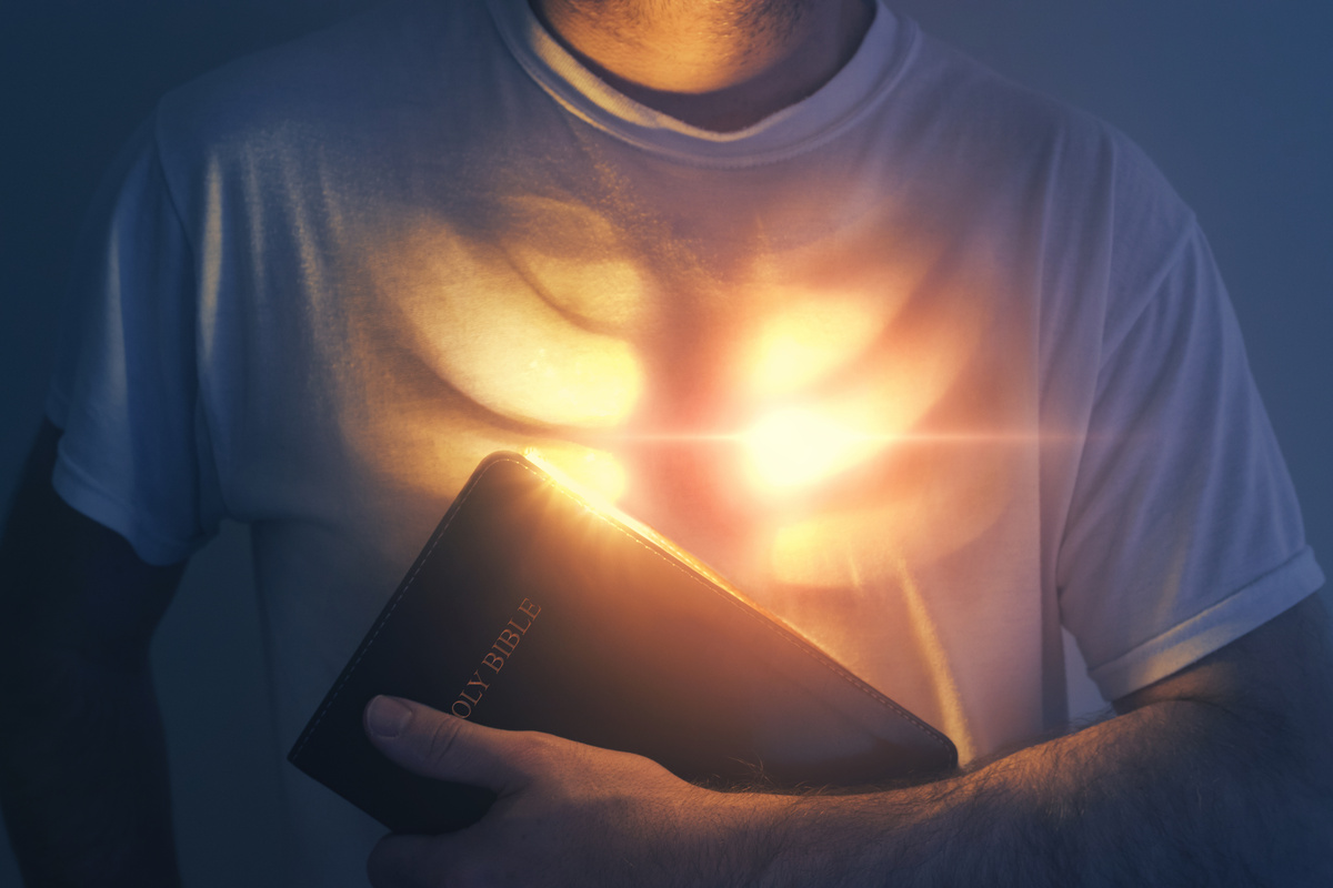 Bíblia iluminando o peito de um homem.