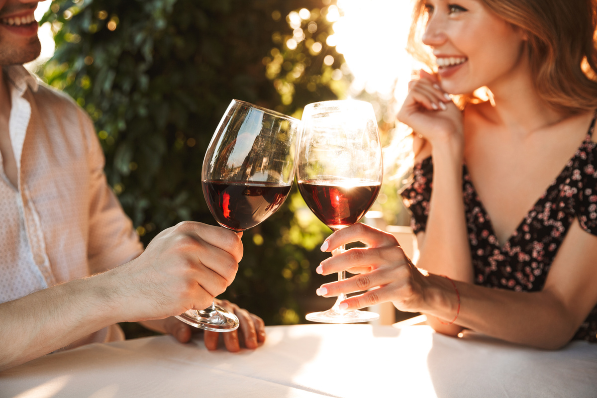 Um homem e uma mulher brindando com taças de vinho
