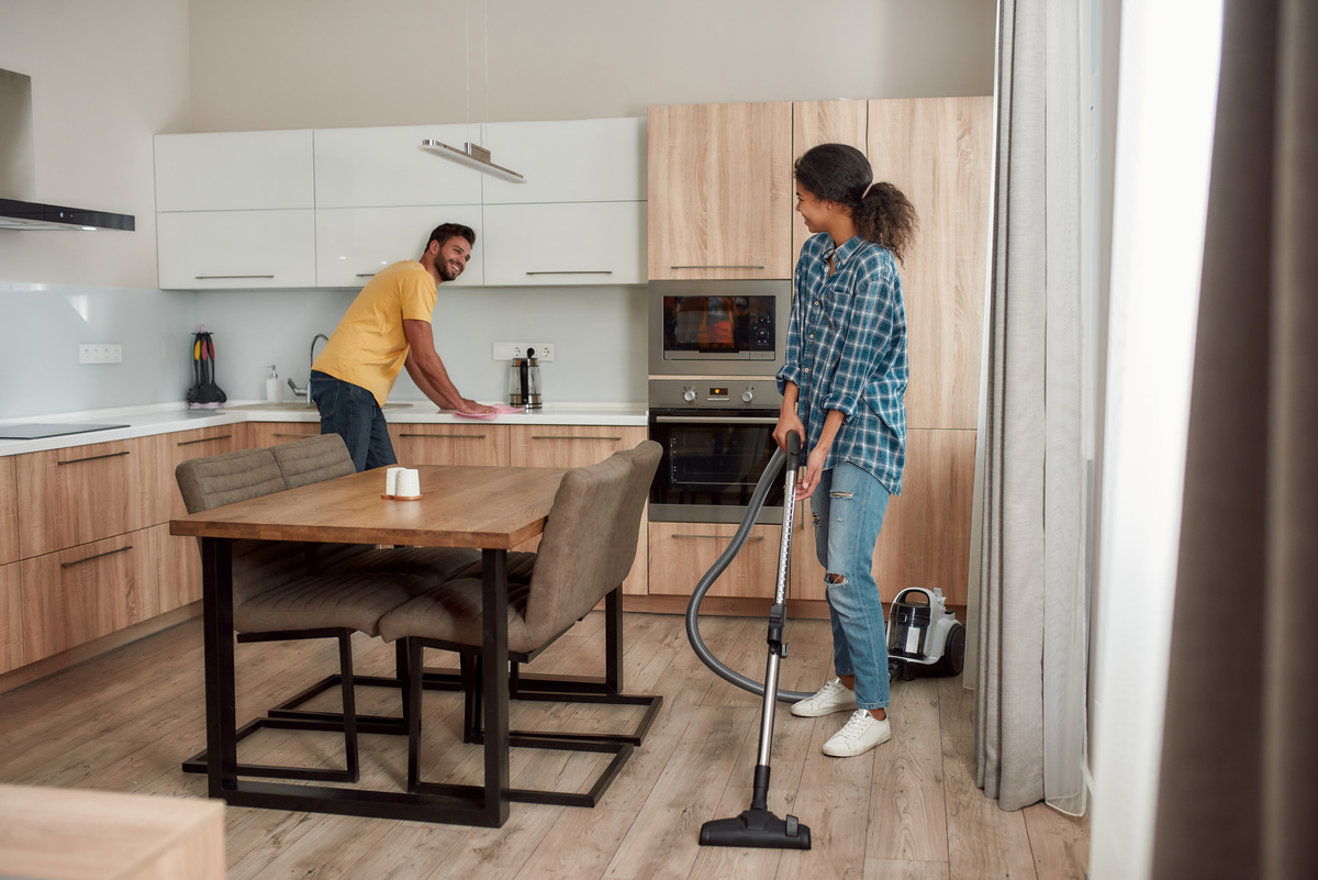 Um homem e uma mulher limpando a cozinha