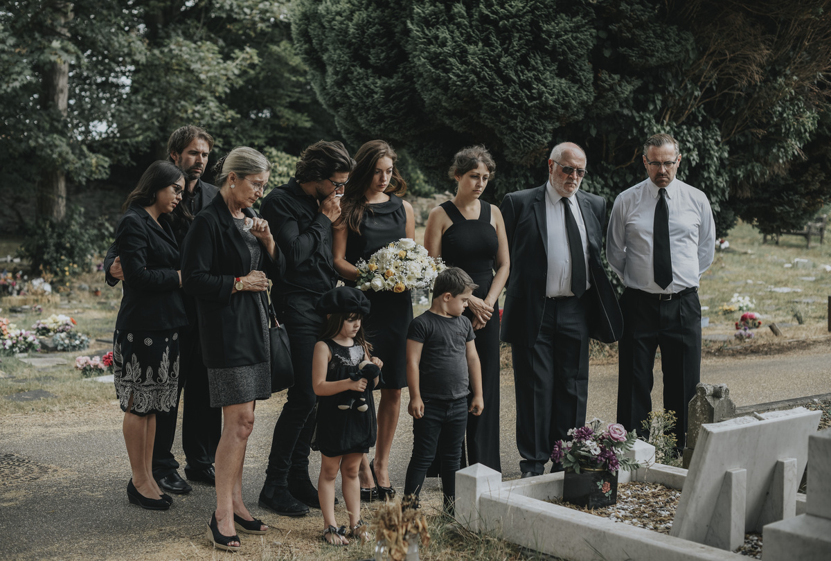 Família triste em frente a túmulo da mãe