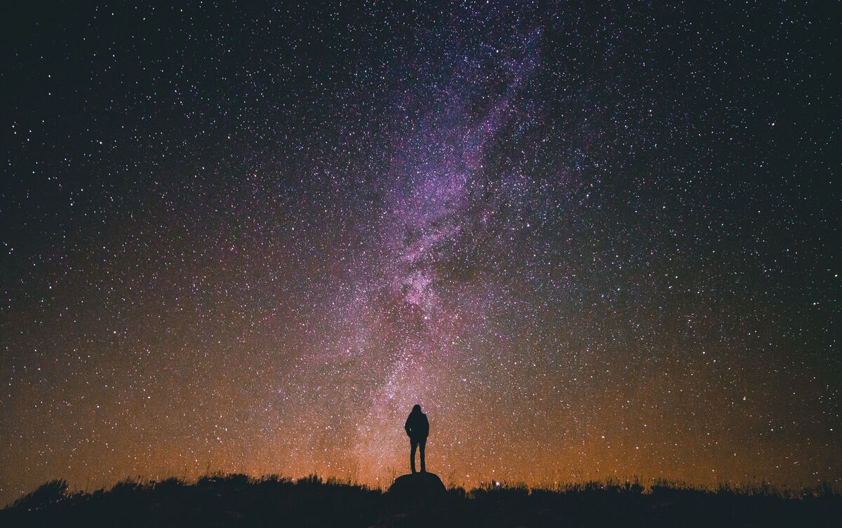 Pessoa observando céu com estrelas.