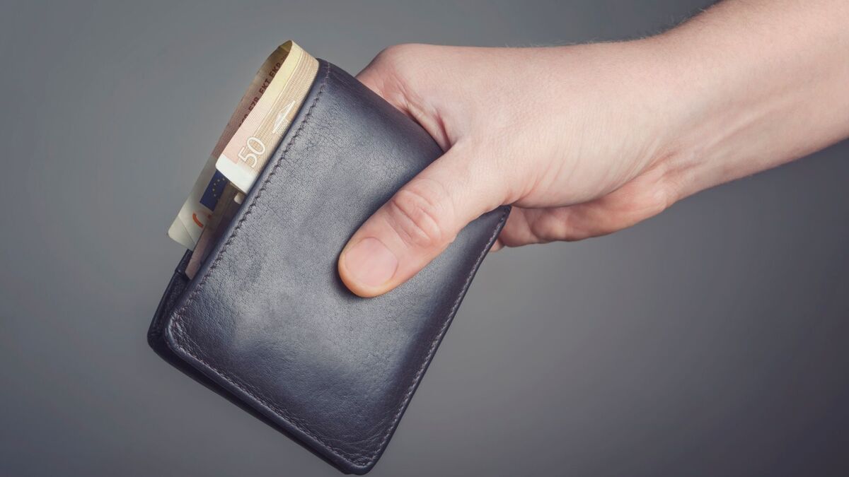 Uma mão segurando uma carteira.