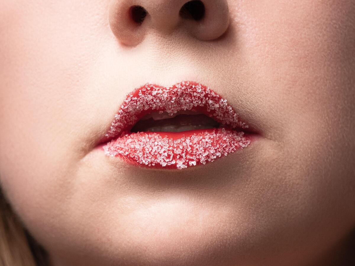 Lábios de uma mulher cobertos com açúcar. 