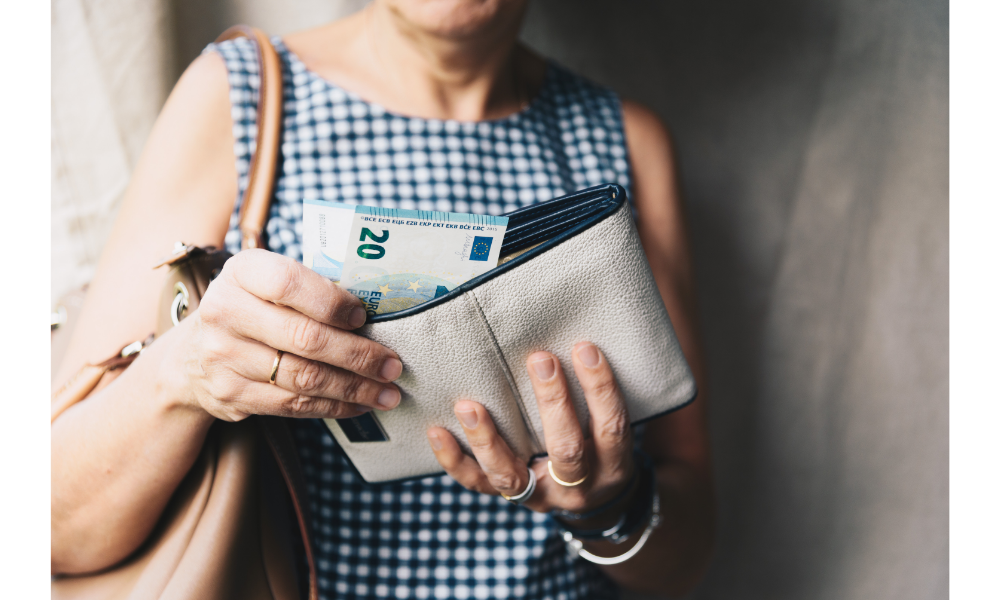Mulher contando notas de dinheiro em sua carteira.