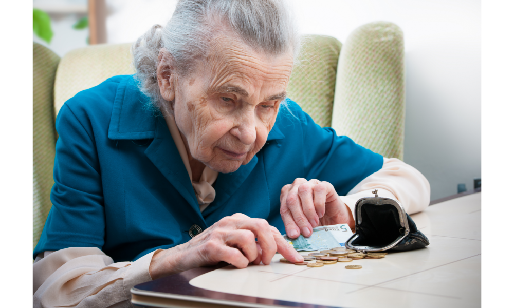 Senhora de idade contando dinheiro em uma mesa.